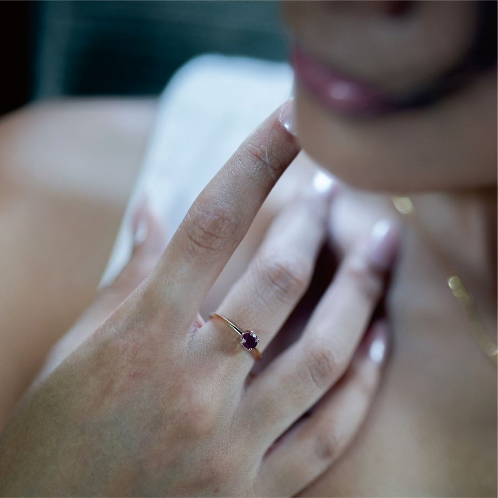 Close-up of a hand with a ring featuring a natural ruby set in 14ct gold,