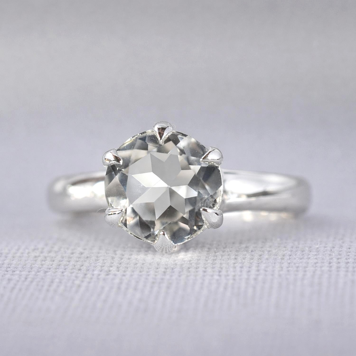 A sterling silver ring featuring a large, round, faceted white topaz gemstone in a prong setting.