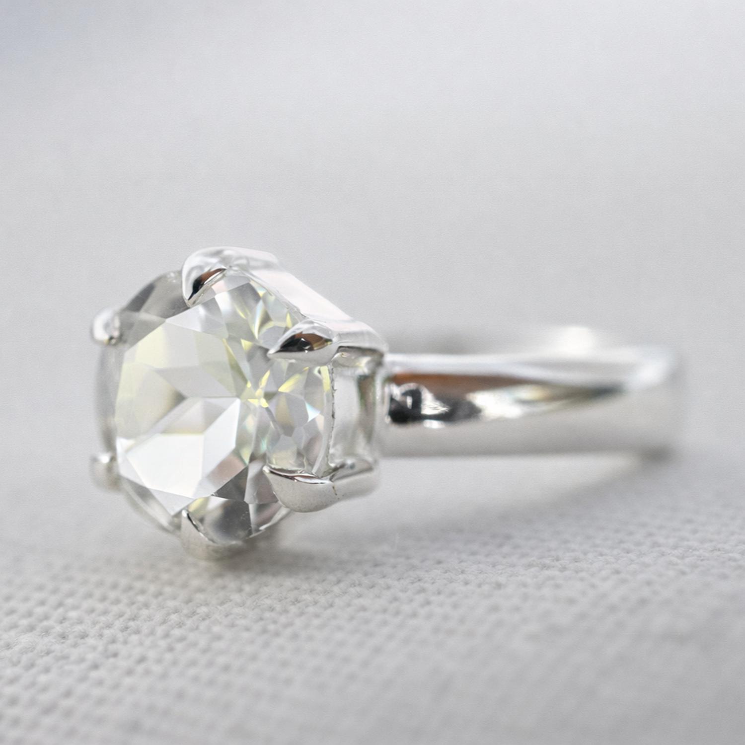 A classic solitaire ring featuring a large, round brilliant-cut clear White Topaz gemstone in a sterling silver classic claw setting